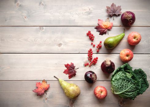 Selection of natural food ingredients with autumn leafs over a wooden background with space 