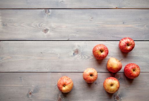 Red apples over a wooden background