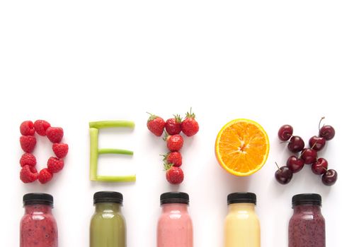 Detox word made with fruits from assorted fruit smoothies over a white background 