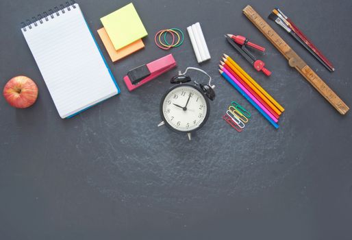 Education stationery accessories on top of a chalkboard with space 