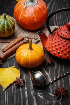 Warming autumn tea and teapot on background of pumpkin