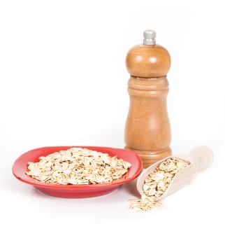 red dish  with oats flakes pile on white background.