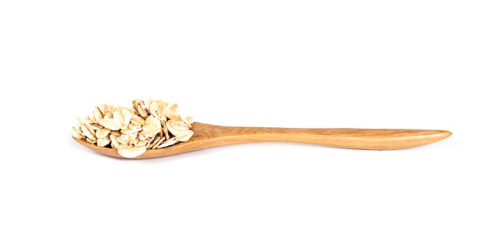 Wooden bowl with oats flakes pile on white background.