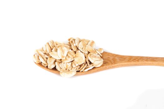 Oats flakes pile in wood spoon on white background