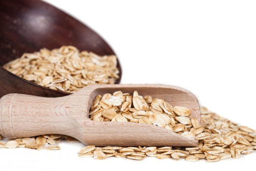 Oats flakes pile in wood spoon on white background