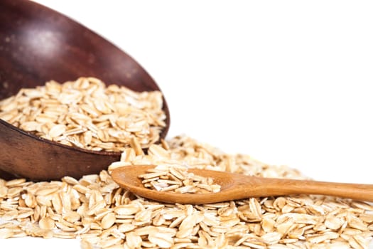 Oats flakes pile in wood spoon on white background