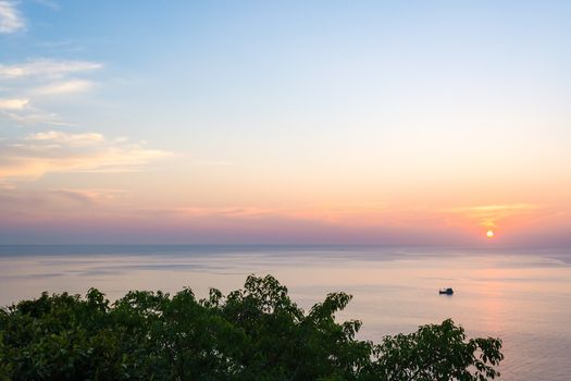 Wide angle seascape view of a boat on sunset.