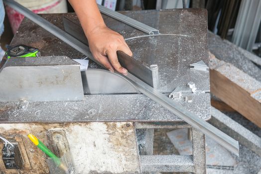 A man using machine to cut aluminum.