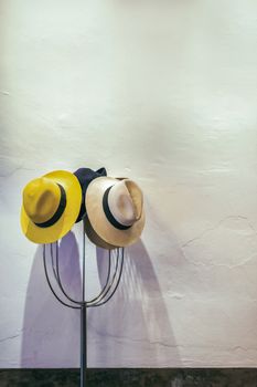 Hats on hanger, white wall background, selective focus.