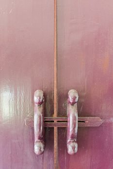 Old style wooden latch in red-purple color.