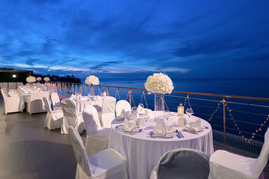 Romantic dinner setup, decoration with candle light. Selective focus. Twilight.