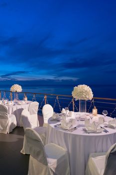 Romantic dinner setup, decoration with candle light. Selective focus. Twilight.