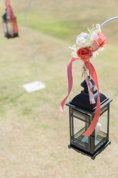A decorated black lantern, floral and ribbon in wedding.