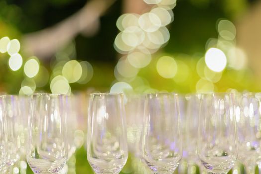 Row of wine glasses in green background painted with beautiful bokeh.