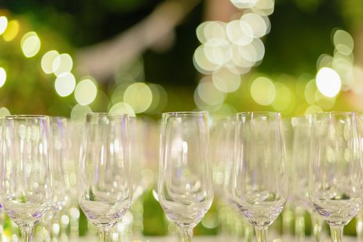 Row of wine glasses in green background painted with beautiful bokeh.