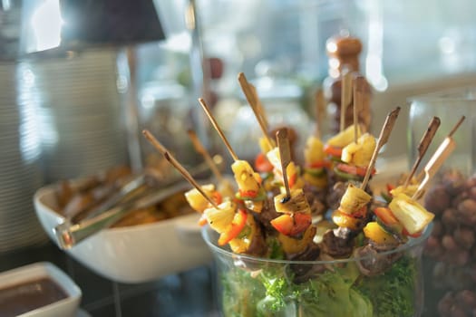 Beef skewers served on a beaker with grilled pineapple, tomato and paprika.