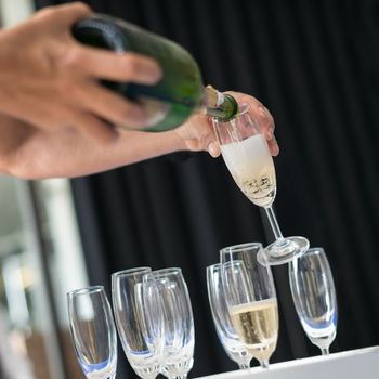 Man pouring champagne into glass, selective focus.