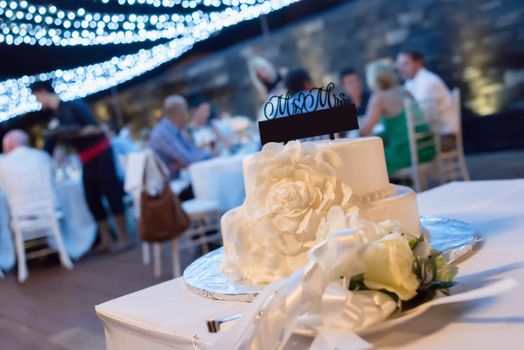 The white wedding cake, decorated with cream cakes floral. Selective focus.