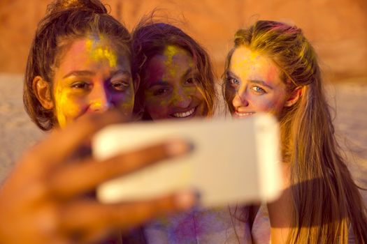 Teenagers making a selfie after playing with colored powder