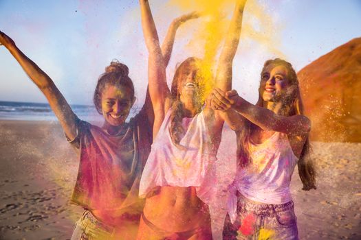 Teenagers playing with colored powder on the beach