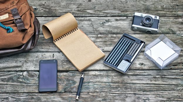 Vintage hipster wooden desktop top view, male hands using a laptop and holding a cup of coffee