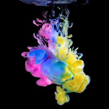 Colored ink drops in water on black background