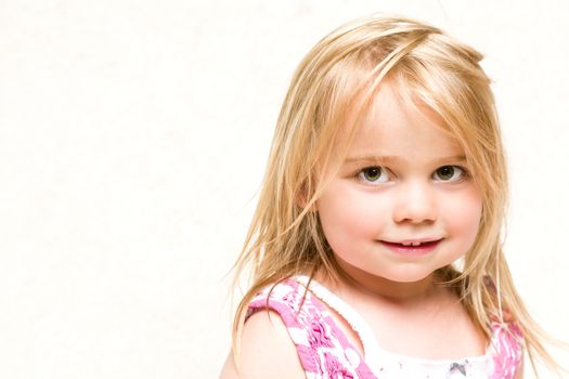 Closeup Headshot Portrait of Beautiful Smiling Toddler Girl with Tousled Blonde Hair