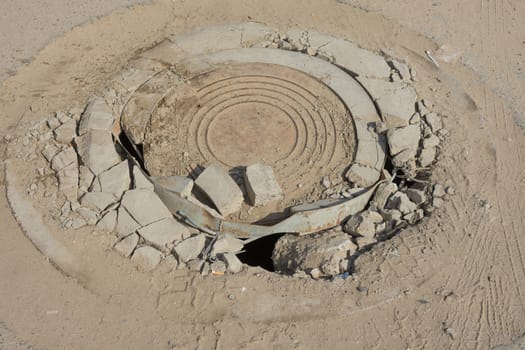 Destroyed well with cast iron lid on the dusty road