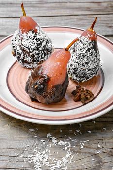 Dessert of pears with chocolate syrup and coconut flakes