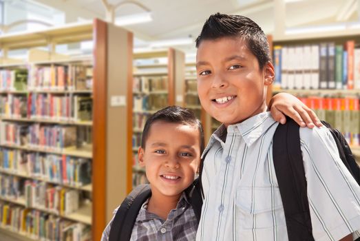 Happy Young Hispanic Student Brothers In Library.