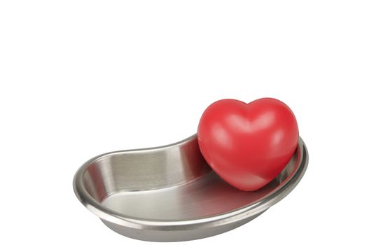 Red heart in stainless steel kidney-shaped bowl placed supine isolated on white background.