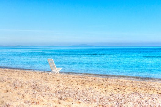 white chair on the beach in a summer day in sardinia