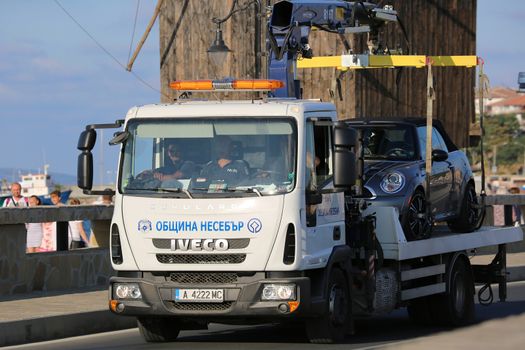 Nessebar, Bulgaria - July 16, 2016:  Tow Truck Iveco Eurocargo Takes Away Illegal Parked Car in The Town of Nessebar in Bulgaria
