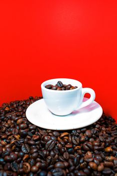 A coffee cup full of beans in a red background