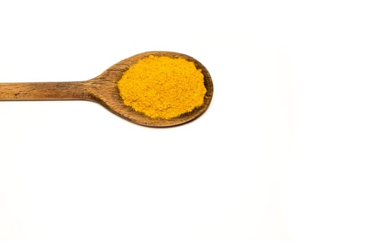 A wooden spoon with curry in a white background