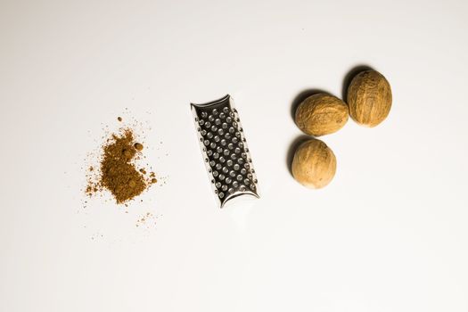 Nutmeg nut and powder in a white background