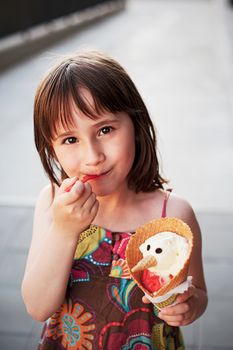 Cute girl eating ice-cream  outside on summer sunset