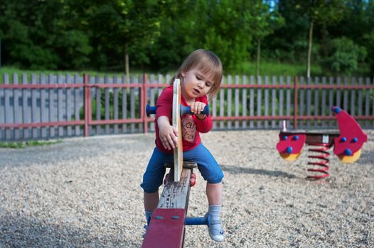 Little girl playing on a teeter on the playground
