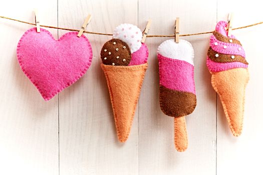 Love, Valentines Day. Heart and couple sweet ice cream, Handmade, hanging on rope. Vintage romantic style, white wooden background, toned. Vivid unusual creative greeting card, multicolored felt