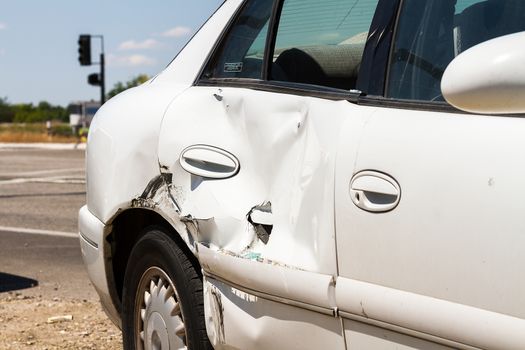 AFter a large hit a car is dented on the side of the road