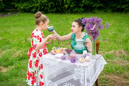 Young mother and her daughter cooking cupcakes together in the backyard