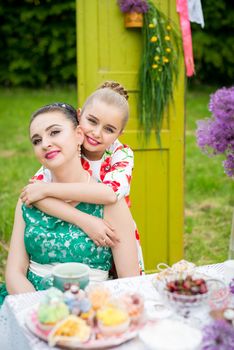 Young mother and her daughter cooking cupcakes together in the backyard