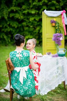 Young mother and her daughter cooking cupcakes together in the backyard