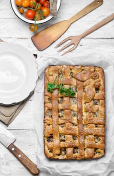Traditional meat pie on the kitchen table on a light background