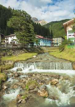 mountain river flowing through village in the Alps
