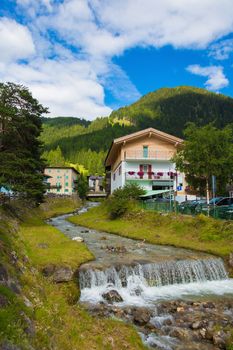 mountain river flowing through village in the Alps