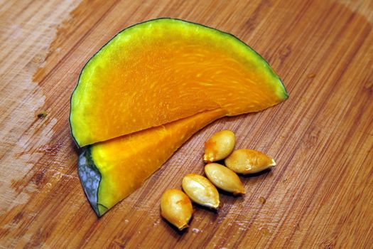 Slices of honeydew pumpkin on a wooden background