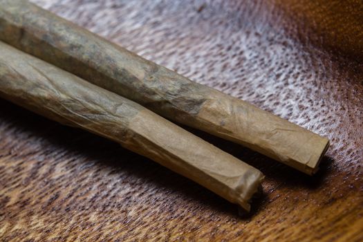 stock of hand made marijuana joints on wooden platter ashtray