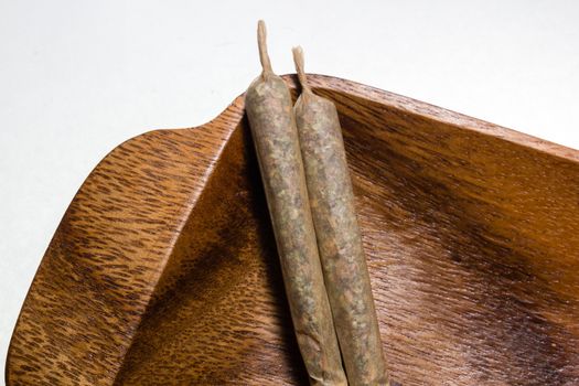 stock of hand made marijuana joints on wooden platter ashtray