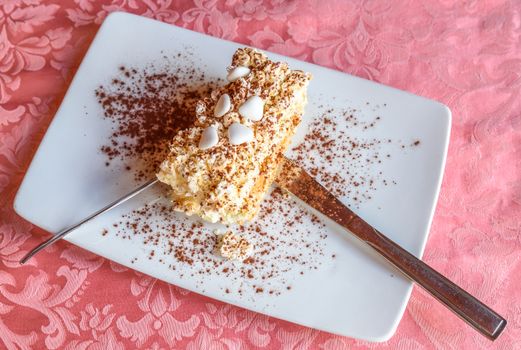 Meringue with cacao and white sugared almonds on white plate,photo from above.